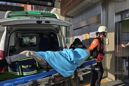 29일 오전 전남 무안국제공항에서 발생한 여객기 사고에서 구조된 승무원이 소방대원들에 의해 목포의 한 병원으로 이송되고 있다.  <연합뉴스>
